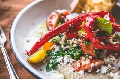 Miniature Traiteur Saint-Gilles (Bruxelles-Capitale) - La Tricoterie Traiteur #11 Une personne manipule une pâte à pizza en la faisant tourner dans un environnement de cuisine.