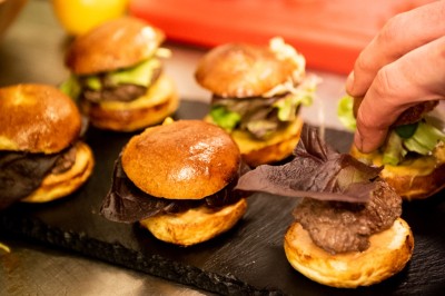 Miniature Traiteur Saint-Gilles (Bruxelles-Capitale) - La Tricoterie Traiteur #2 Une personne manipule une pâte à pizza en la faisant tourner dans un environnement de cuisine.