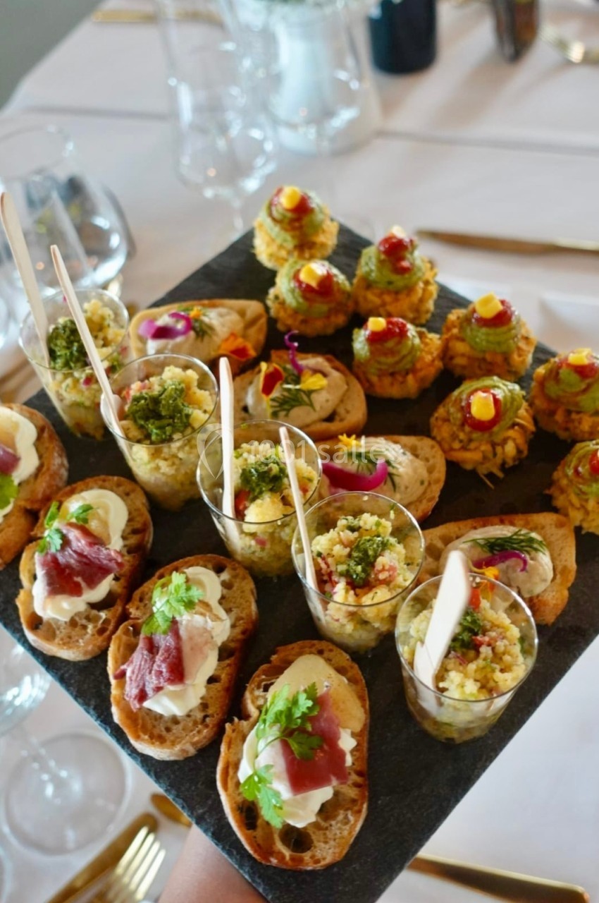Plateau de canapés variés comprenant toasts, verrines et bouchées garnies de légumes, jambon et herbes fraîches.
