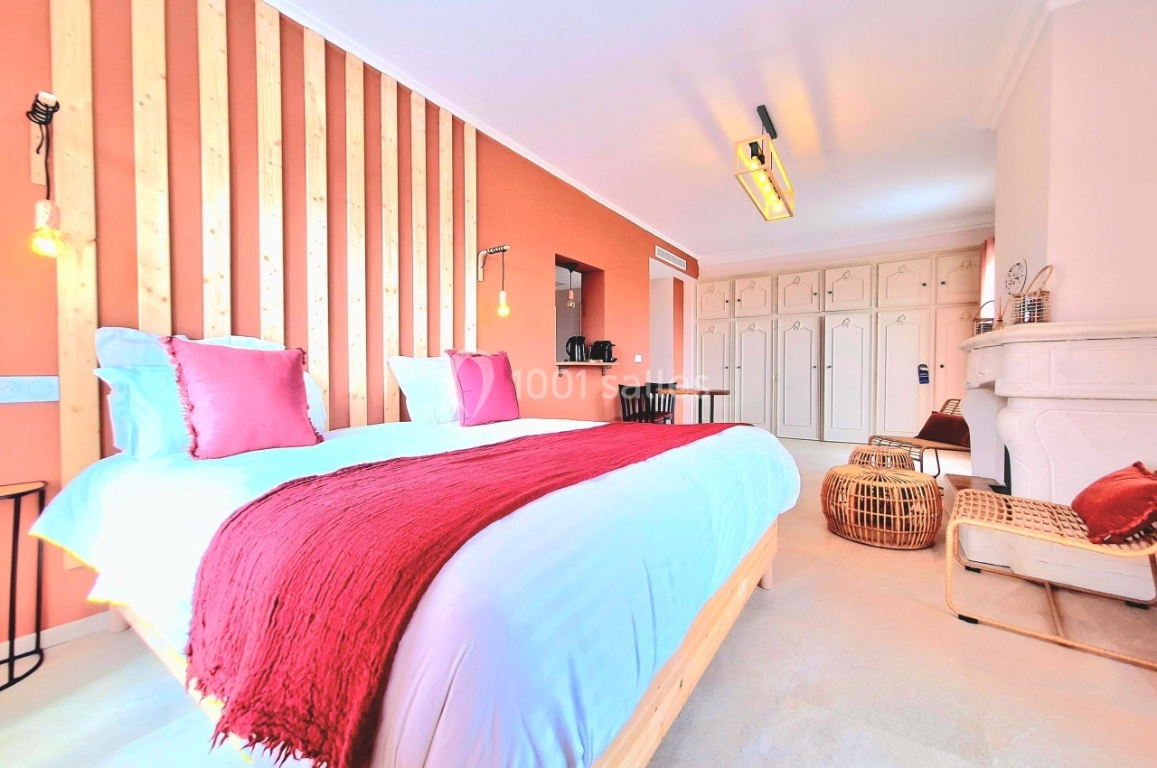 Chambre lumineuse avec lit double, mur en bois, décoration chaleureuse et mobilier moderne.