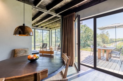 Rangée de vélos électriques noirs et rouges alignés dans un entrepôt avec des supports de rangement en arrière-plan.