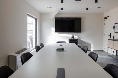 Rangée de vélos électriques noirs et rouges alignés dans un entrepôt avec des supports de rangement en arrière-plan.