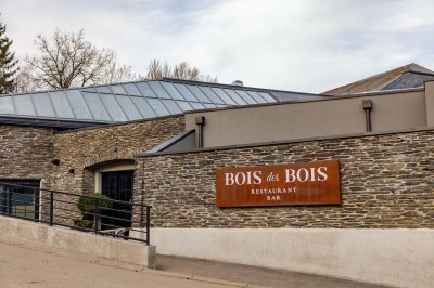 Rangée de vélos électriques noirs et rouges alignés dans un entrepôt avec des supports de rangement en arrière-plan.