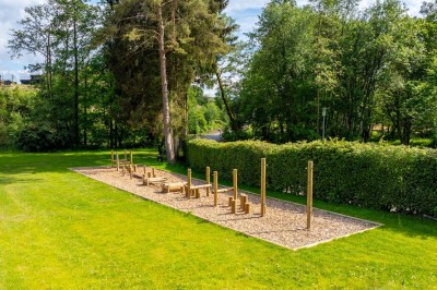 Rangée de vélos électriques noirs et rouges alignés dans un entrepôt avec des supports de rangement en arrière-plan.
