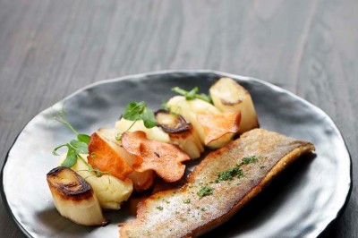 Rangée de vélos électriques noirs et rouges alignés dans un entrepôt avec des supports de rangement en arrière-plan.