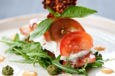 Rangée de vélos électriques noirs et rouges alignés dans un entrepôt avec des supports de rangement en arrière-plan.