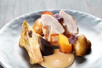 Rangée de vélos électriques noirs et rouges alignés dans un entrepôt avec des supports de rangement en arrière-plan.