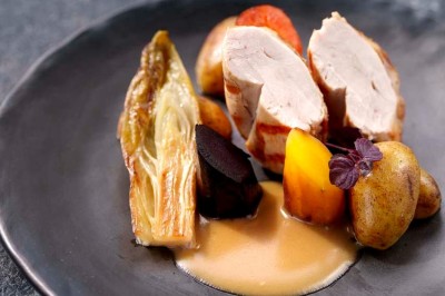 Rangée de vélos électriques noirs et rouges alignés dans un entrepôt avec des supports de rangement en arrière-plan.