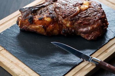 Rangée de vélos électriques noirs et rouges alignés dans un entrepôt avec des supports de rangement en arrière-plan.
