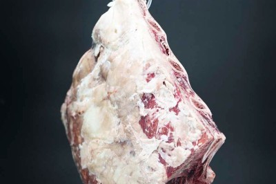 Rangée de vélos électriques noirs et rouges alignés dans un entrepôt avec des supports de rangement en arrière-plan.