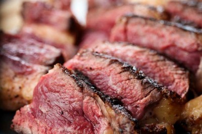 Rangée de vélos électriques noirs et rouges alignés dans un entrepôt avec des supports de rangement en arrière-plan.