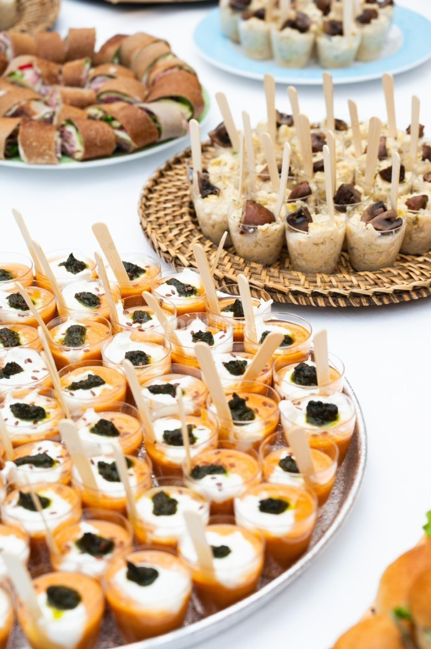 Plateau de verrines et amuse-bouches variés disposés sur une table, prêts à être servis lors d'un événement.