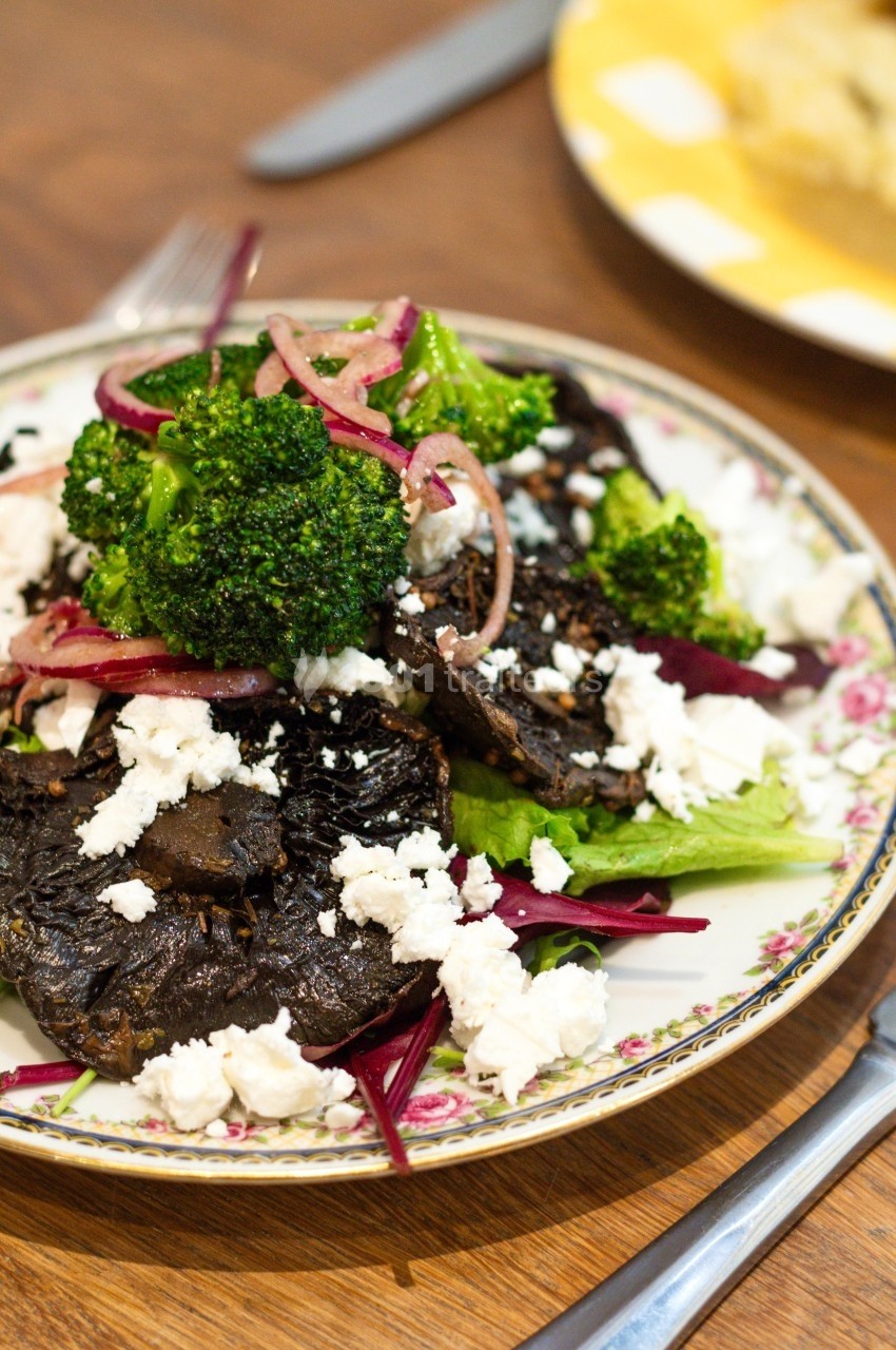 Assiette de salade composée de champignons grillés, brocolis, fromage émietté et légumes verts.
