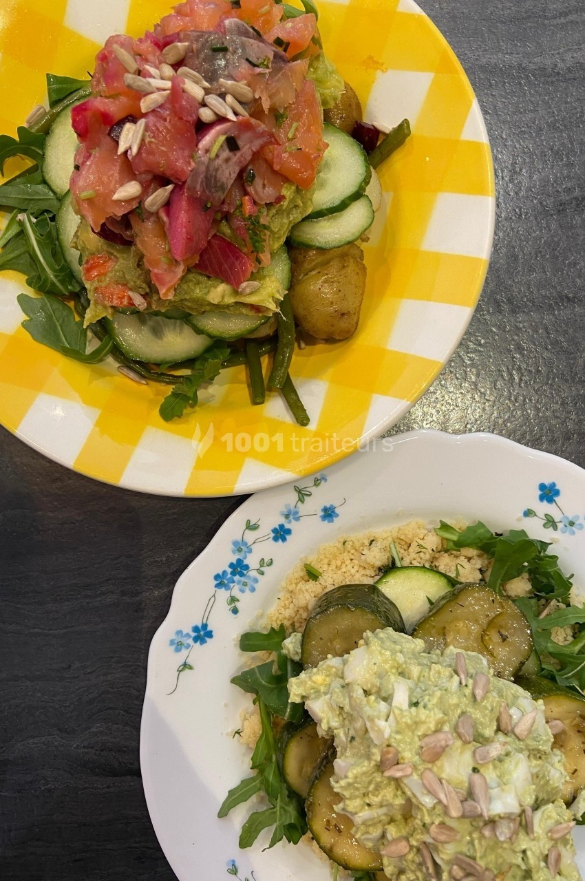 Deux assiettes garnies de légumes frais, saumon, avocat et graines, présentées sur des assiettes colorées.