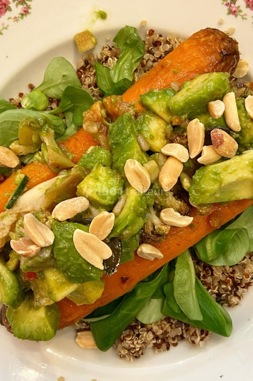Assiette de quinoa garnie de carottes rôties, dés d'avocat, mâche et amandes effilées.