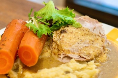 Assiette de magret de canard tranché sur purée de patates douces, garni de persil et accompagné d'une sauce.