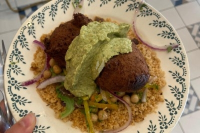 Assiette de magret de canard tranché sur purée de patates douces, garni de persil et accompagné d'une sauce.