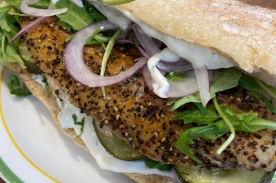 Assiette de magret de canard tranché sur purée de patates douces, garni de persil et accompagné d'une sauce.