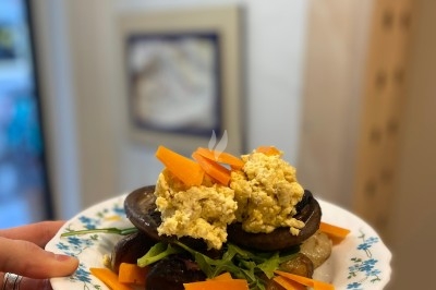 Assiette de magret de canard tranché sur purée de patates douces, garni de persil et accompagné d'une sauce.