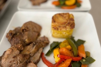 Miniature Traiteur Crosne (Essonne) - Aux Tulipes Traiteur #13 Assiette de burrata garnie de tomates cerises colorées et décorée d'une fleur violette sur une assiette blanche.