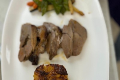 Miniature Traiteur Crosne (Essonne) - Aux Tulipes Traiteur #18 Assiette de burrata garnie de tomates cerises colorées et décorée d'une fleur violette sur une assiette blanche.