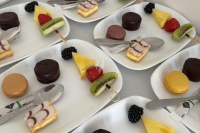 Miniature Traiteur Crosne (Essonne) - Aux Tulipes Traiteur #37 Assiette de burrata garnie de tomates cerises colorées et décorée d'une fleur violette sur une assiette blanche.