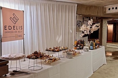 Miniature Traiteur Crosne (Essonne) - Aux Tulipes Traiteur #9 Assiette de burrata garnie de tomates cerises colorées et décorée d'une fleur violette sur une table blanche.