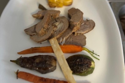 Miniature Traiteur Crosne (Essonne) - Aux Tulipes Traiteur #26 Assiette de burrata garnie de tomates cerises colorées et décorée d'une fleur violette sur une table blanche.