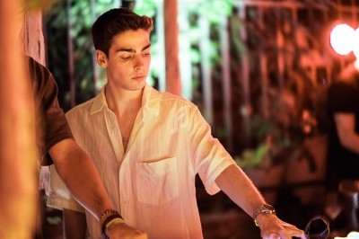 Miniature DJ Albigny-sur-Saône (Rhône) - Teebow #6 Un DJ mixe devant une foule dans une boîte de nuit éclairée par des lumières roses et des boules à facettes.