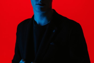 Miniature DJ Albigny-sur-Saône (Rhône) - Teebow #12 Un DJ mixe devant une foule dans une boîte de nuit éclairée par des lumières roses et des boules à facettes.