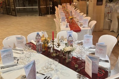 Groupe de personnes debout dans une salle en pierre avec des lumières suspendues au plafond.