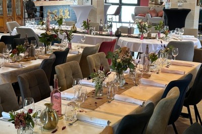 Groupe de personnes debout dans une salle en pierre avec des lumières suspendues au plafond.