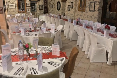 Groupe de personnes debout dans une salle en pierre avec des lumières suspendues au plafond.