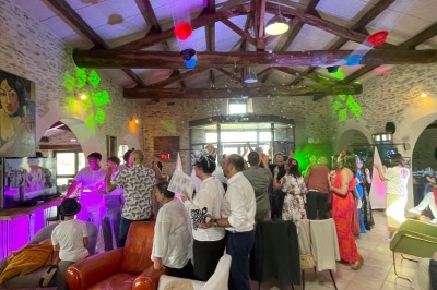 Groupe de personnes debout dans une salle en pierre avec des lumières suspendues au plafond.