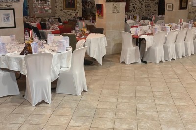 Groupe de personnes debout dans une salle en pierre avec des lumières suspendues au plafond.