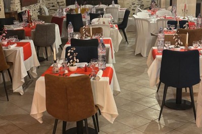 Groupe de personnes debout dans une salle en pierre avec des lumières suspendues au plafond.