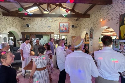Groupe de personnes debout dans une salle en pierre avec des lumières suspendues au plafond.