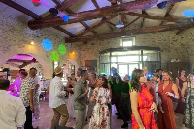 Groupe de personnes debout dans une salle en pierre avec des lumières suspendues au plafond.