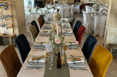 Groupe de personnes debout dans une salle en pierre avec des lumières suspendues au plafond.
