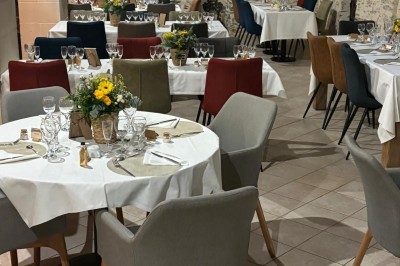 Groupe de personnes debout dans une salle en pierre avec des lumières suspendues au plafond.