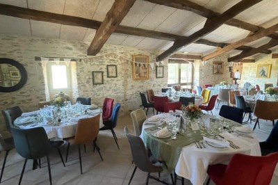 Groupe de personnes debout dans une salle en pierre avec des lumières suspendues au plafond.
