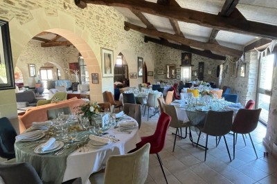 Groupe de personnes debout dans une salle en pierre avec des lumières suspendues au plafond.