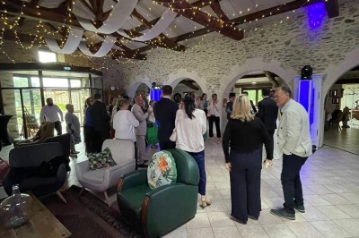 Groupe de personnes debout dans une salle en pierre avec des lumières suspendues au plafond.