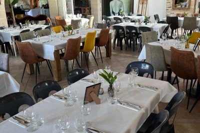 Groupe de personnes debout dans une salle en pierre avec des lumières suspendues au plafond.
