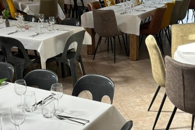 Groupe de personnes debout dans une salle en pierre avec des lumières suspendues au plafond.