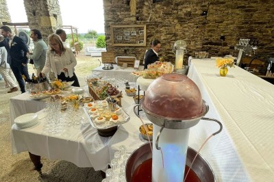 Groupe de personnes debout dans une salle en pierre avec des lumières suspendues au plafond.