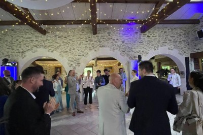 Groupe de personnes debout dans une salle en pierre avec des lumières suspendues au plafond.