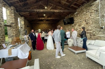 Groupe de personnes debout dans une salle en pierre avec des lumières suspendues au plafond.