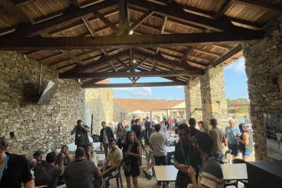 Groupe de personnes debout dans une salle en pierre avec des lumières suspendues au plafond.