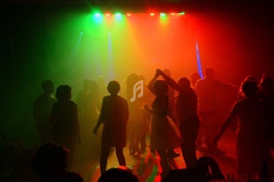 Miniature DJ Chignin (Savoie) - Anim'Fab #17 Un homme chante sur scène avec un micro, éclairé par une lumière rouge dans une ambiance sombre.